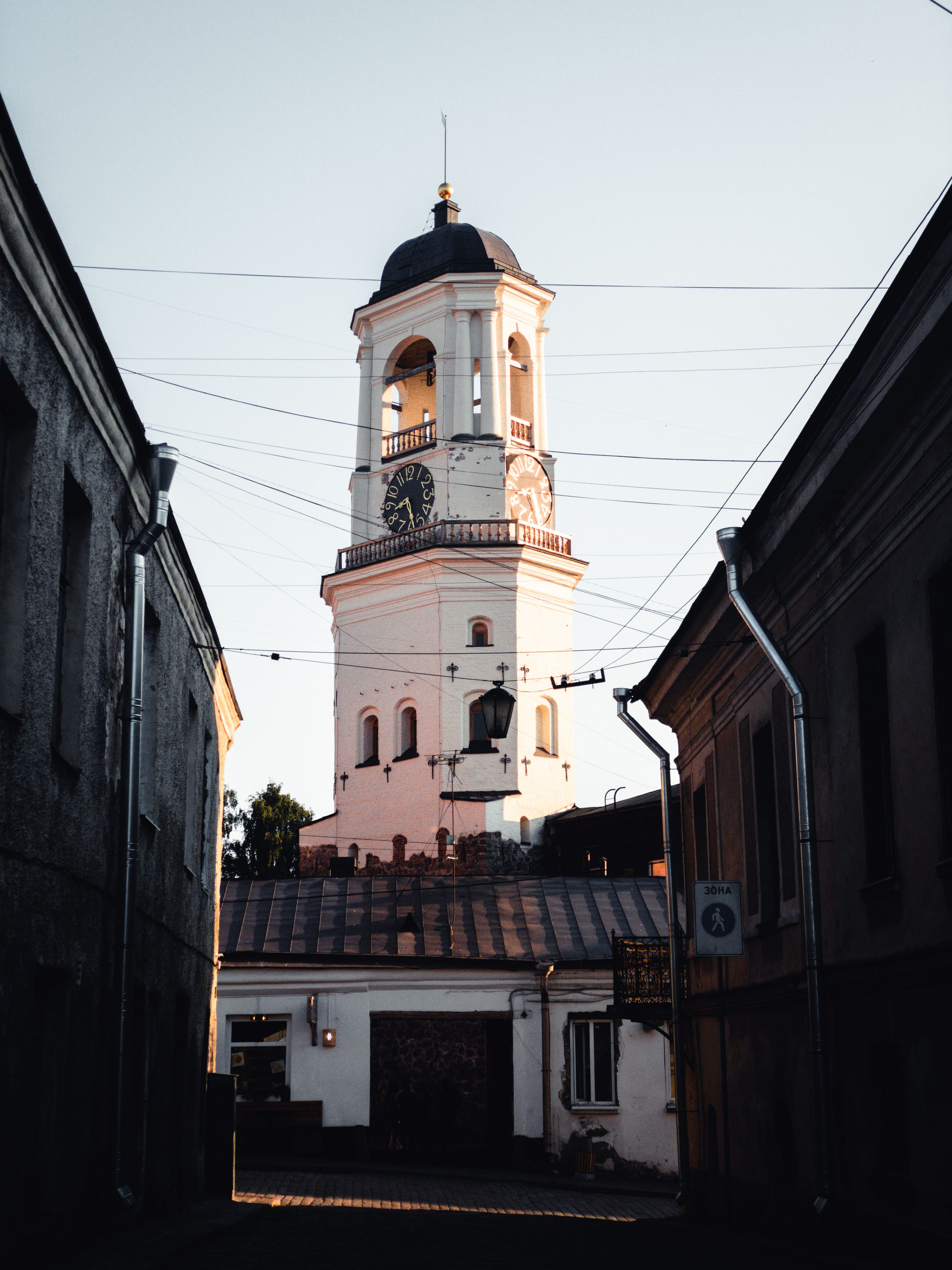 Historic clock tower seen through a street in Vyborg